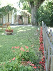 a garden with red flowers and a fence at Fondo Riso in Faenza