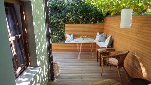un patio con mesa y sillas en una terraza de madera en Haus zum wilden Manne en Erfurt