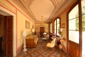 sala de estar con muebles y lámpara de araña. en Agriturismo Villa Panigai, en Farra di Soligo