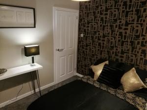 a living room with a black couch and a wall at The Hedgehogs in Inverness