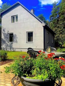 una casa con una mesa y flores delante de ella en 9 Mežmalas iela en Jūrmala