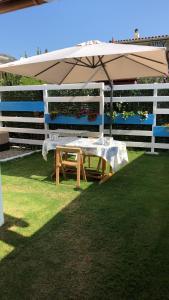 a picnic table with an umbrella on the grass at Dépendance in San Vito