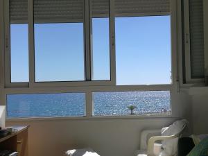 トレビエハにあるUna ventana al marの海の景色を望む客室内の窓3つ
