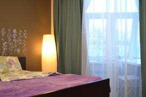um quarto com uma cama com um candeeiro e uma janela em Hostel Zolotoye Koltso em Yaroslavl