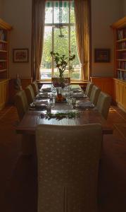 een lange tafel in een kamer met stoelen en een groot raam bij B&B Villa Anna, Venlo in Venlo