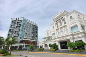 ein großes weißes Gebäude neben einem hohen Gebäude in der Unterkunft One Madison Place Tower 1 in Iloilo City