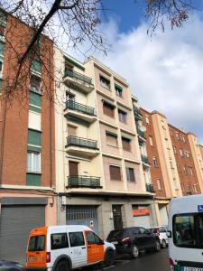 una furgoneta blanca y naranja estacionada frente a un edificio en La Campa 7.2 en Logroño