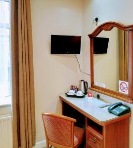 a room with a vanity with a mirror and a chair at Thirteen On The Green - Eyre Square in Galway