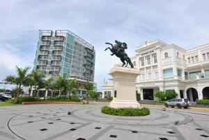 a statue in the middle of a plaza with buildings at One Madison Place Tower 1 in Iloilo City