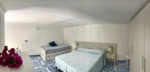 um quarto com uma cama e uma cadeira em Casetta del pescatore em Ischia