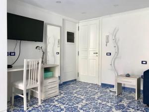 um quarto com uma secretária, uma cadeira e uma mesa em Casetta del pescatore em Ischia