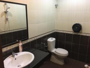 bagno con servizi igienici, lavandino e specchio di Meng Meng GuestHouse a Kuantan