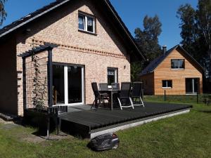 a house with a deck with a table and chairs at Birkenhainring 34 in Trassenheide