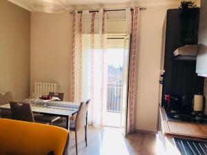 een eetkamer met een tafel en een deur naar een balkon bij SL Apartament in San Gregorio di Catania