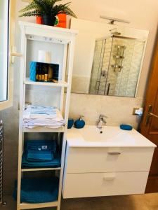 een badkamer met een wastafel en een spiegel bij SL Apartament in San Gregorio di Catania