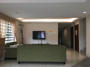 un soggiorno con divano e TV a parete di Meng Meng GuestHouse a Kuantan