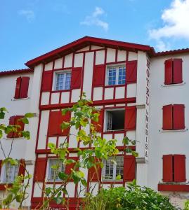 a red and white building with red windows at Hôtel La Marisa Grande Plage in Saint-Jean-de-Luz