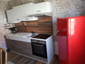 eine Küche mit einem roten Kühlschrank und weißen Schränken in der Unterkunft Köhlers Ferienhaus in Schöppenstedt