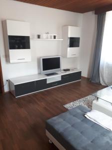 Ferienwohnung Frank في Merzalben: غرفة معيشة مع تلفزيون بشاشة مسطحة على طاولة