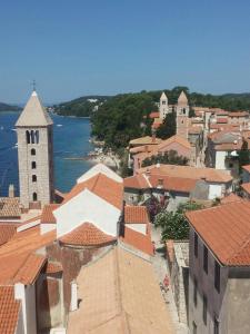 a view of a town with a church and water at Apartments & Rooms Brna in Rab