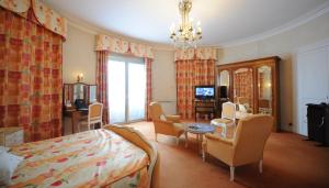 - une chambre avec un lit et un salon dans l'établissement Hôtel Continental Pau Centre, à Pau