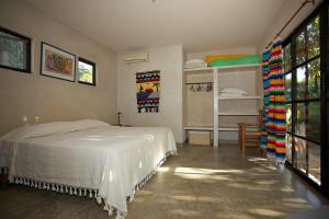 a bedroom with a bed and a room with a window at Sole Caliente in Todos Santos