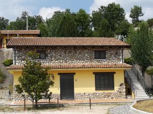a yellow house with a stone wall at Agriturismo I Tre Ulivi in Paternopoli