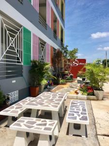 a group of picnic tables in front of a building at The Rich Home in Nakhon Ratchasima
