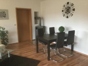 a dining room with a black table and chairs at FW Sonnenschein in Wechterswinkel