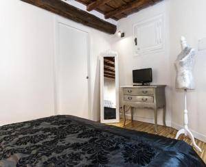 a bedroom with a bed and a dresser and a television at Urbana 33 in Rome