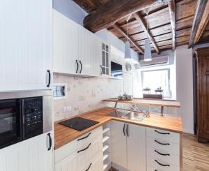 a kitchen with white cabinets and a wooden counter top at Urbana 33 in Rome