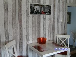 ザスニッツにあるFischerhaus König in Alt Sassnitzのテーブルと白い椅子2脚が備わる客室です。