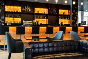 a bar with a leather couch in front of a bar at Grand Spa Hotel Avax in Krasnodar