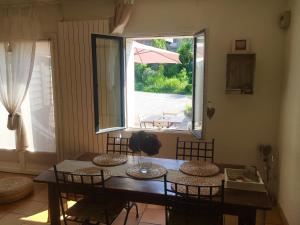 jadalnia ze stołem i krzesłami oraz oknem w obiekcie Le Clos du Carpe Diem w mieście Cambligneul