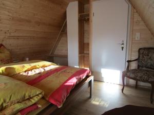 a bedroom with a bed and a chair in a room at Mandauhaus mit Sauna in Hainewalde