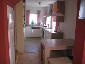 a kitchen with a wooden table and a dining room at Mandauhaus mit Sauna in Hainewalde