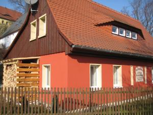 a orange house with a brown roof at Mandauhaus mit Sauna in Hainewalde