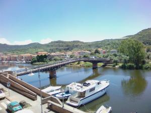 a boat is docked in a river with a bridge at B&B Vista Fiume in Bosa