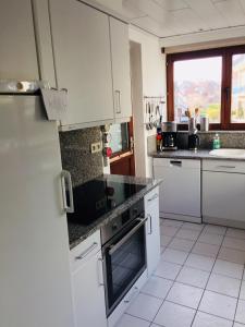 een keuken met witte apparatuur en een raam bij villa Suècia in De Panne