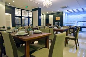 a restaurant with tables and chairs and a chandelier at A'Sinamar Hotel Apartment in Muscat