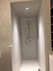 a shower in a bathroom with a wall at villa Suècia in De Panne