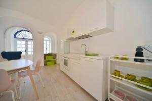 a white kitchen with a table and a dining room at Bistrot del mare in Santo Stefano al Mare +77 photos