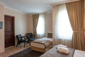 a hotel room with a bedroom with a bed and a chair at Sultanahmet Cesme Hotel in Istanbul