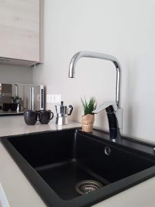 a black kitchen sink with a faucet in a kitchen at Alfred's Apartments - Lindargata in Reykjavík