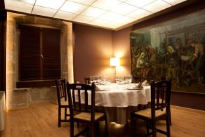 una sala da pranzo con tavolo e un dipinto sul muro di Hotel Cardenal Ram a Morella