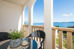 una mesa y sillas en un balcón con vistas al océano en Appartments Villa Daria en Marusici 