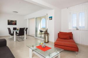 uma sala de estar com um sofá vermelho e uma mesa em Appartments Villa Daria em Marusici 