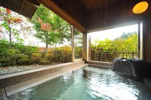 a swimming pool in a house with a large window at Meigetsuso in Kaminoyama