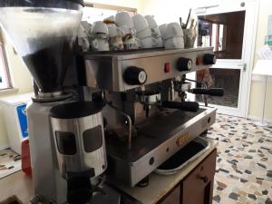 una macchinetta del caffè con tazze sopra in cucina di Hotel Ottavia a Rimini