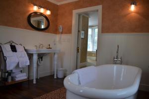 a bathroom with a white tub and a sink at Maplewood Hotel in Saugatuck